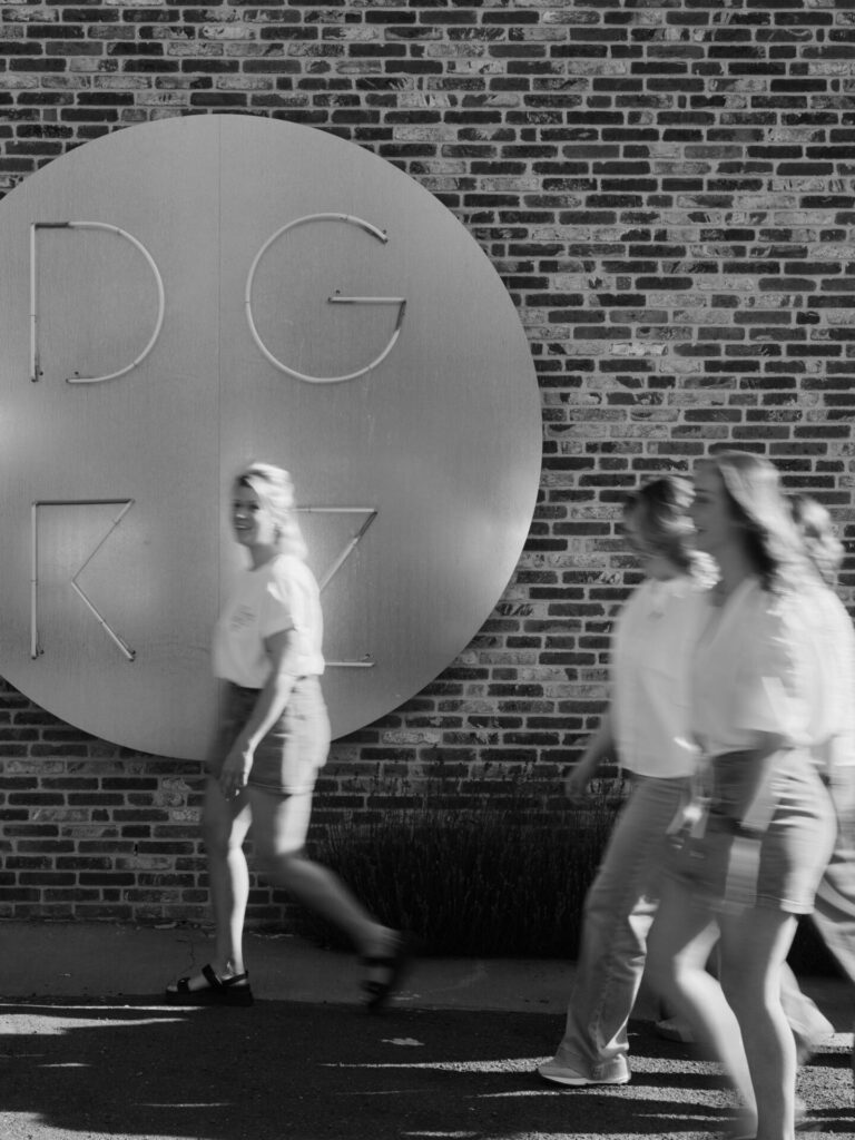 Team van De Geknipte Zaak voor het logo op de muur, zwart-wit