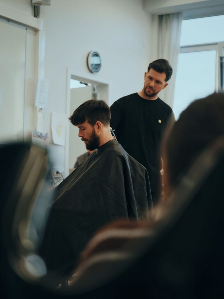 Barber knipt een klant in een lichte barbershop