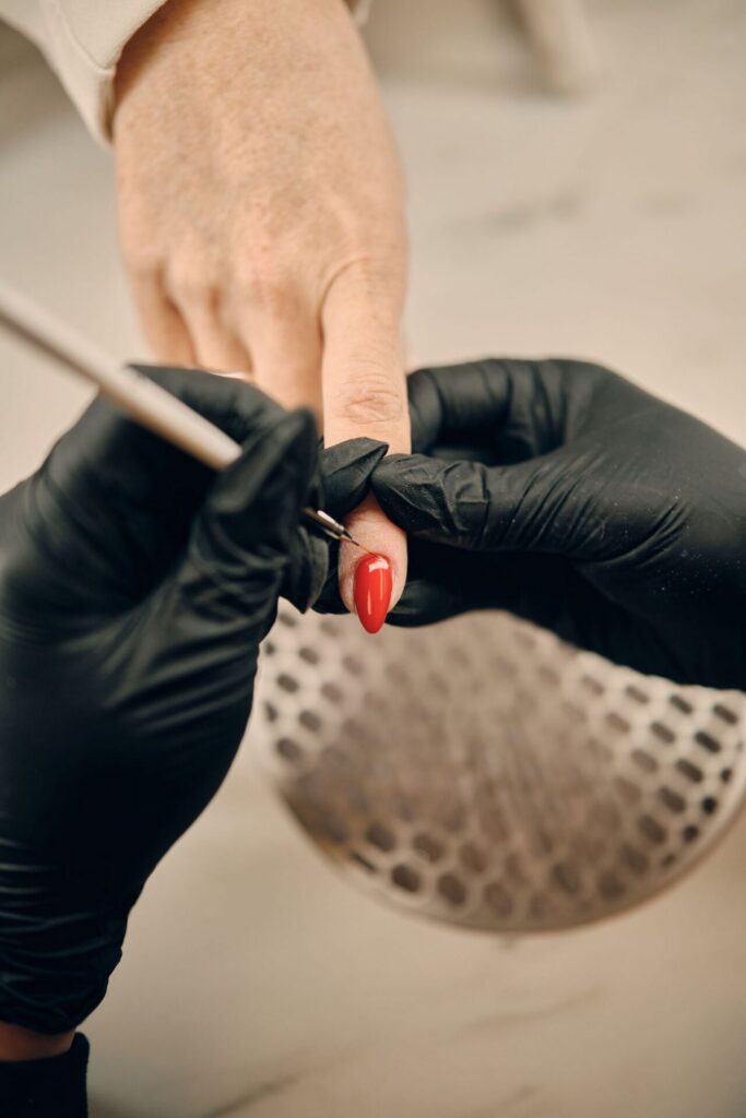 Rode gellak wordt aangebracht tijdens een manicure
