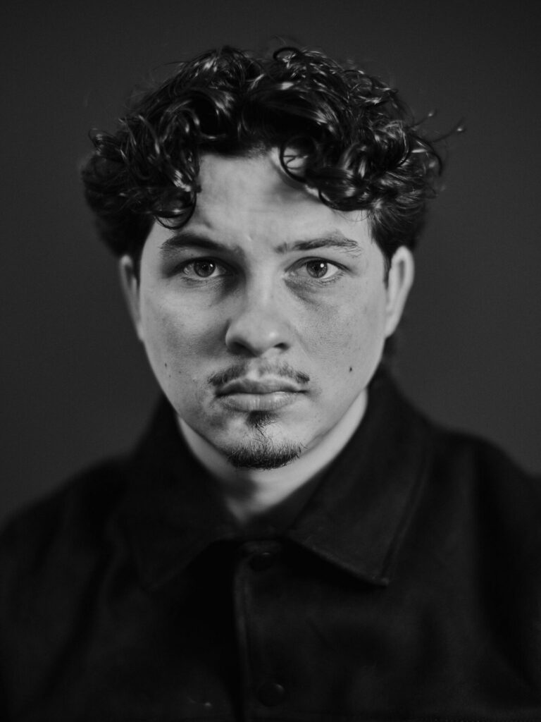 Zwart-witportret van een jonge man met krullen